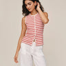Woman wearing a red and white striped sleeveless top with white pants on a beige background