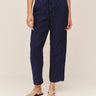 Navy blue pants worn by a person on a plain background