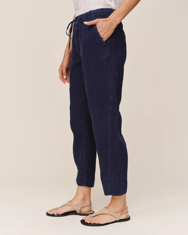 Navy blue pants worn by a person on a beige background