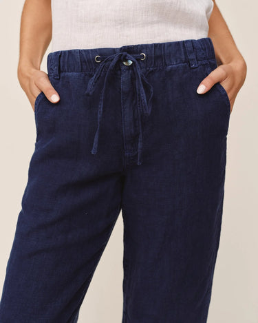 Navy blue pants with a drawstring waist on a beige background