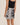 Person wearing a black and white patterned skirt on a beige background