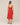 Red dress worn by a person on a beige background