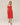 Woman wearing a red dress against a plain background