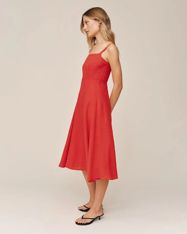 Woman wearing a red dress against a plain background
