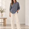 Front view of Bella Dahl Seamed Button Down Shirt in Vintage Navy Stripe styled with ivory wide-leg jeans