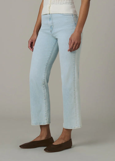 a woman wearing high rise light blue cropped jeans