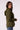 A woman wearing an olive green hooded blazer with a textured knit hood, shown from a side profile against a plain light background.