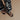 Person wearing black and white zebra-striped pants with black sandals on a beige background
