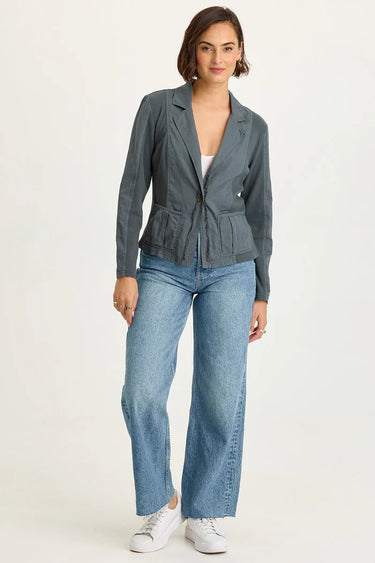Woman wearing a blue jacket and jeans on a white background