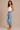 a woman wearing light wash cropped straight jeans on a neutral background