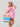 Woman in a pink cover-up holding a colorful striped bag against a gray background