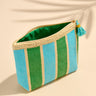 Striped pouch with green and blue stripes on a beige background