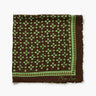 A square brown silk scarf with a green floral pattern and a decorative border, featuring a signature 'Char Lot' in gold on the bottom right corner, displayed flat against a white background.