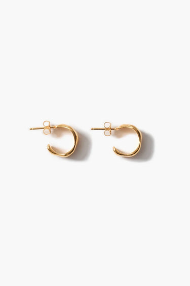 Textured gold cuff hoop earrings on a neutral background.