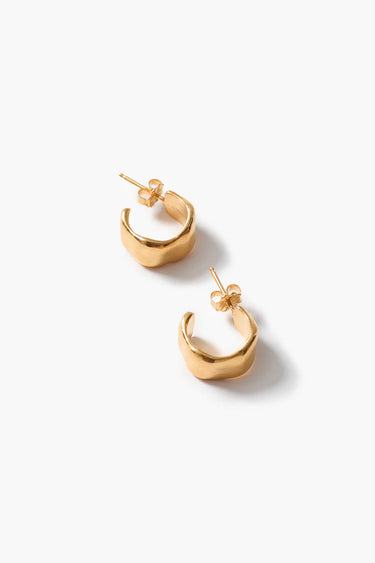 Textured gold cuff hoop earrings on a neutral background.