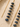 Gold-toned beaded necklace with dark blue stone beads and a long straight gold bar, shown on a light beige textured surface.