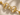 A gold horsebit chain bracelet with a clear square-cut gemstone in the center