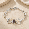 a horsebit bracelet with links and a peacock pearl stone in the center