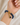 A close-up of a person's wrist wearing a dark blue beaded spiral bracelet with a gold clasp and charm.
