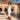 Woman in a white dress standing by a pool with palm trees and mountains in the background
