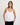 Woman wearing a white spaghetti strap top against a plain background