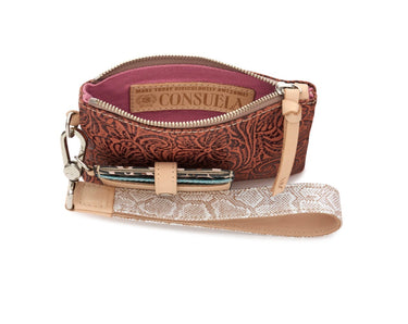 A Consuelo brand zippered wristlet clutch with a brown and red paisley embossed exterior, a pink interior lining, and a beige faux-skin wrist strap with a silver-tone metal clasp.
