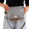 A shoulder bag with a gray and black leopard print pattern, featuring a light tan leather strap and a colorful rainbow-striped elastic band across the front.