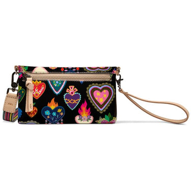 Consuela black crossbody bag with colorful heart and floral print, tan wristlet strap, and striped woven shoulder strap.