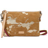 A tan suede crossbody clutch bag with an abstract white paint splatter pattern, featuring a light tan leather wristlet strap and a colorful striped woven shoulder strap, with a 'DON'T BE A TRAP' brand patch on the front.