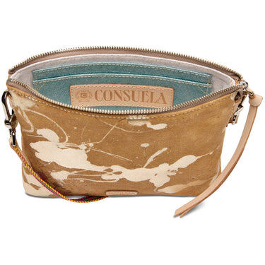 A Consuela zippered clutch or wristlet pouch in a tan and beige distressed paint-splatter pattern, shown open to reveal a teal interior lining and a tan leather brand patch.