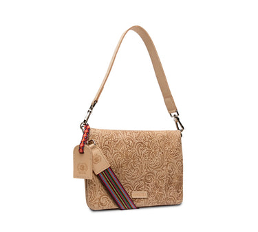 A tan embossed leather shoulder bag with a floral pattern, featuring a matching leather hangtag and a colorful woven accent strap.