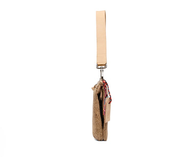 A side profile view of a beige leather wristlet bag with a matching leather strap, featuring a floral embossed pattern and a colorful beaded tassel detail.
