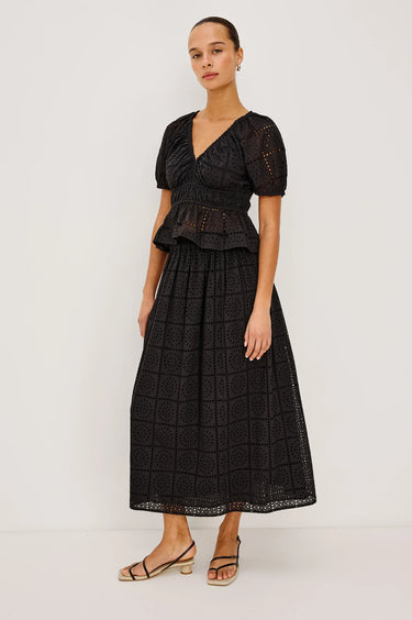 woman wearing black embroidery maxi skirt and blouse on white background