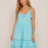 Woman wearing a light blue dress with lace details on a beige background