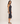 Woman wearing a black sleeveless dress against a plain background