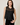 A woman wearing a black mesh, sheer embellished tank with a black tank underneath and black jeans