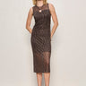 a woman wearing a black mesh dress with brown patterns across the dress