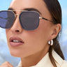 Close-up of a woman wearing sunglasses with a blurred background