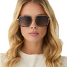 Woman wearing sunglasses with a neutral background