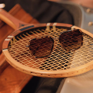 Sunglasses on a wicker chair with a blurred background