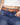 Person wearing blue jeans with a brown studded belt with gold hardware