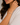 Close-up of a woman wearing a silver bracelet on a neutral background