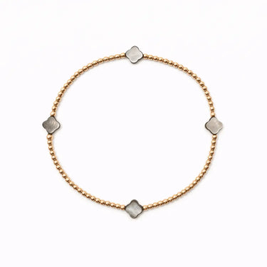 Gold bracelet with silver square charms on a white background