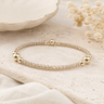 A gold and champagne shimmer beaded bracelet on a table