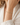 A woman wearing a gold and champagne shimmer beaded bracelet