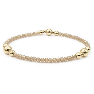 a champagne and gold beaded bracelet on a white background
