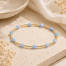 A gold beaded bracelet with blue beaded accents