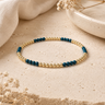 a blue and gold beaded bracelet on a natural background 