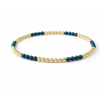 a blue and gold beaded bracelet on a neutral background