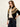 A woman modeling a black zip-up cardigan with a beige and brown geometric Fair Isle pattern on the yoke, styled with a cream t-shirt and dark blue jeans against a plain off-white background.